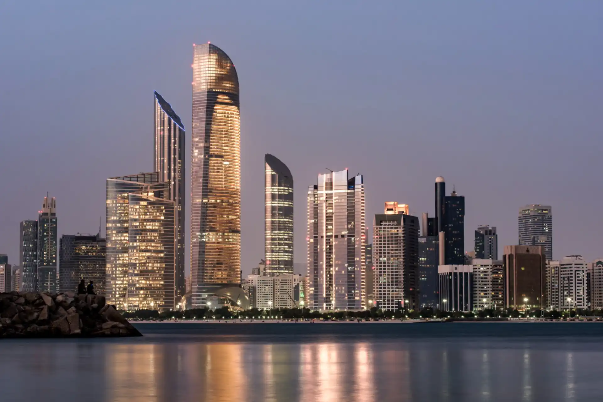 11582 Abu Dhabi skyline at dusk with illuminated buildings.